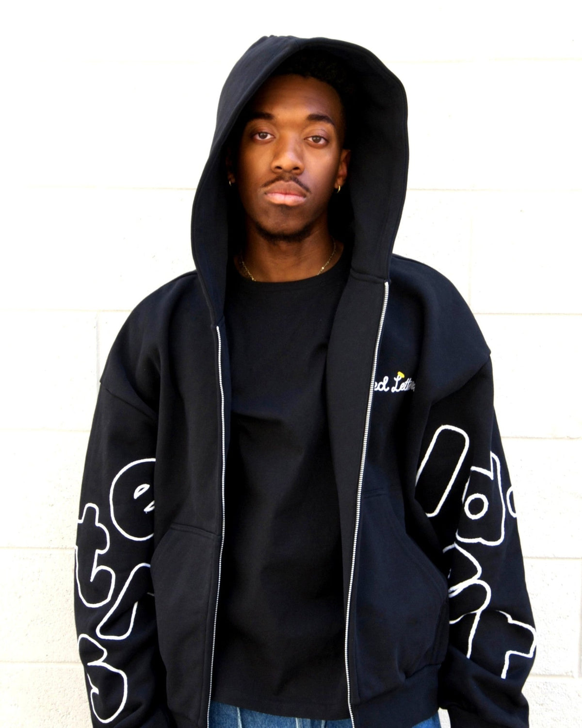 Black Trust Zip-Up Hoodie by Red Letters on model, Trust God chain stitch embroidery