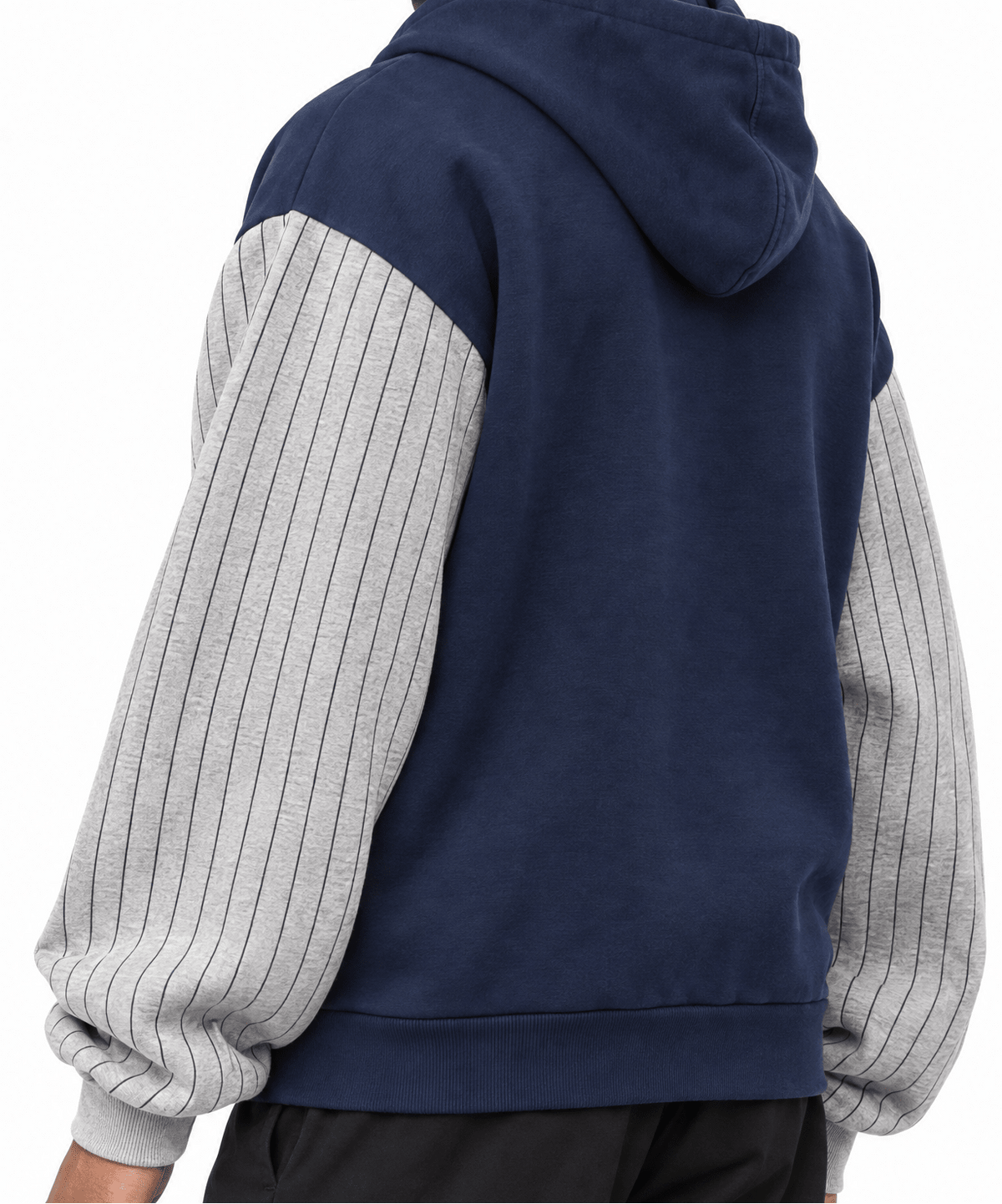 A person shown from the back wearing a color-block hoodie with a navy blue body and light gray pinstriped sleeves, paired with black pants, against a plain white background.