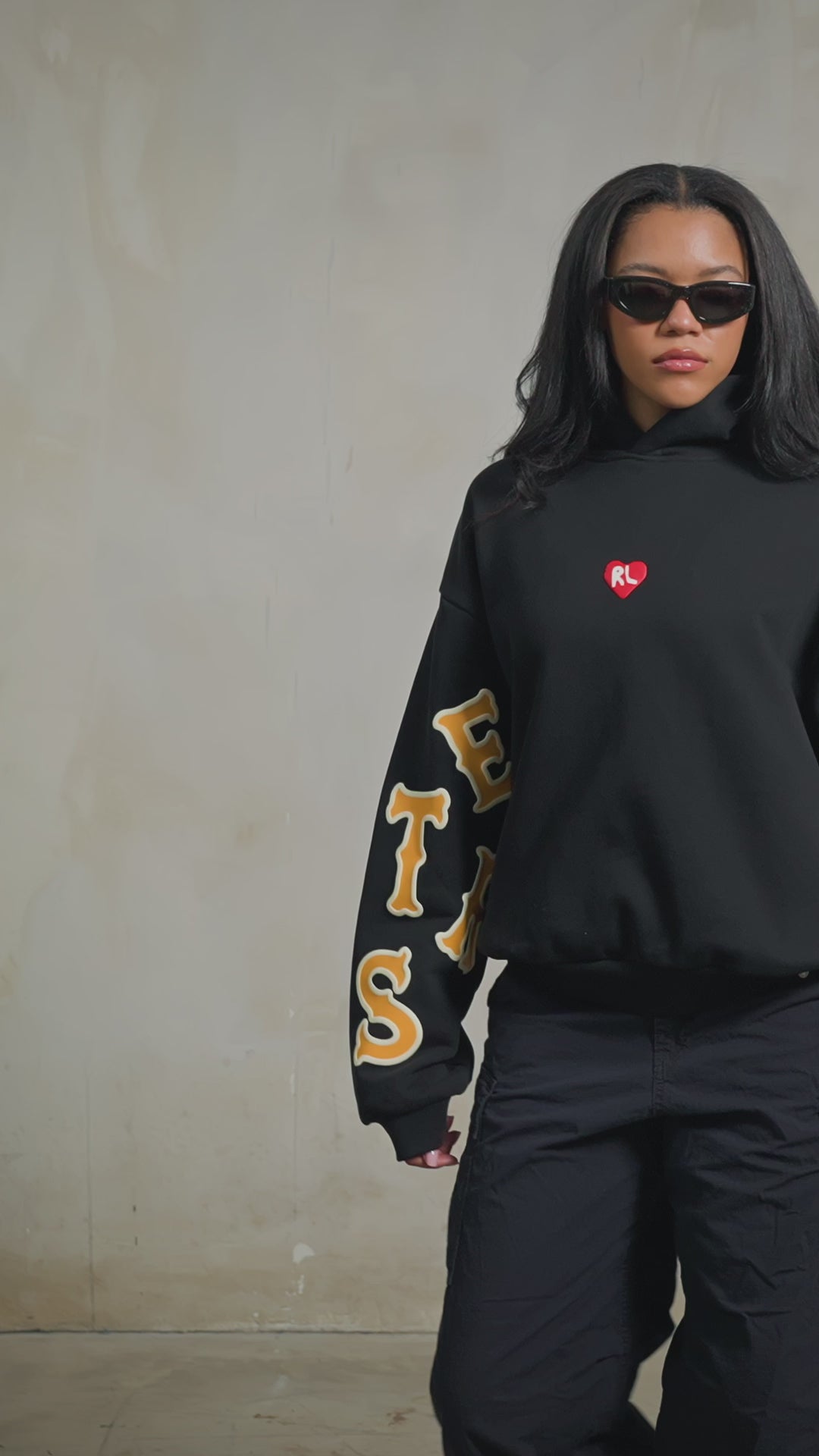 Black Somebody Hoodie — studio fit video, front, female model