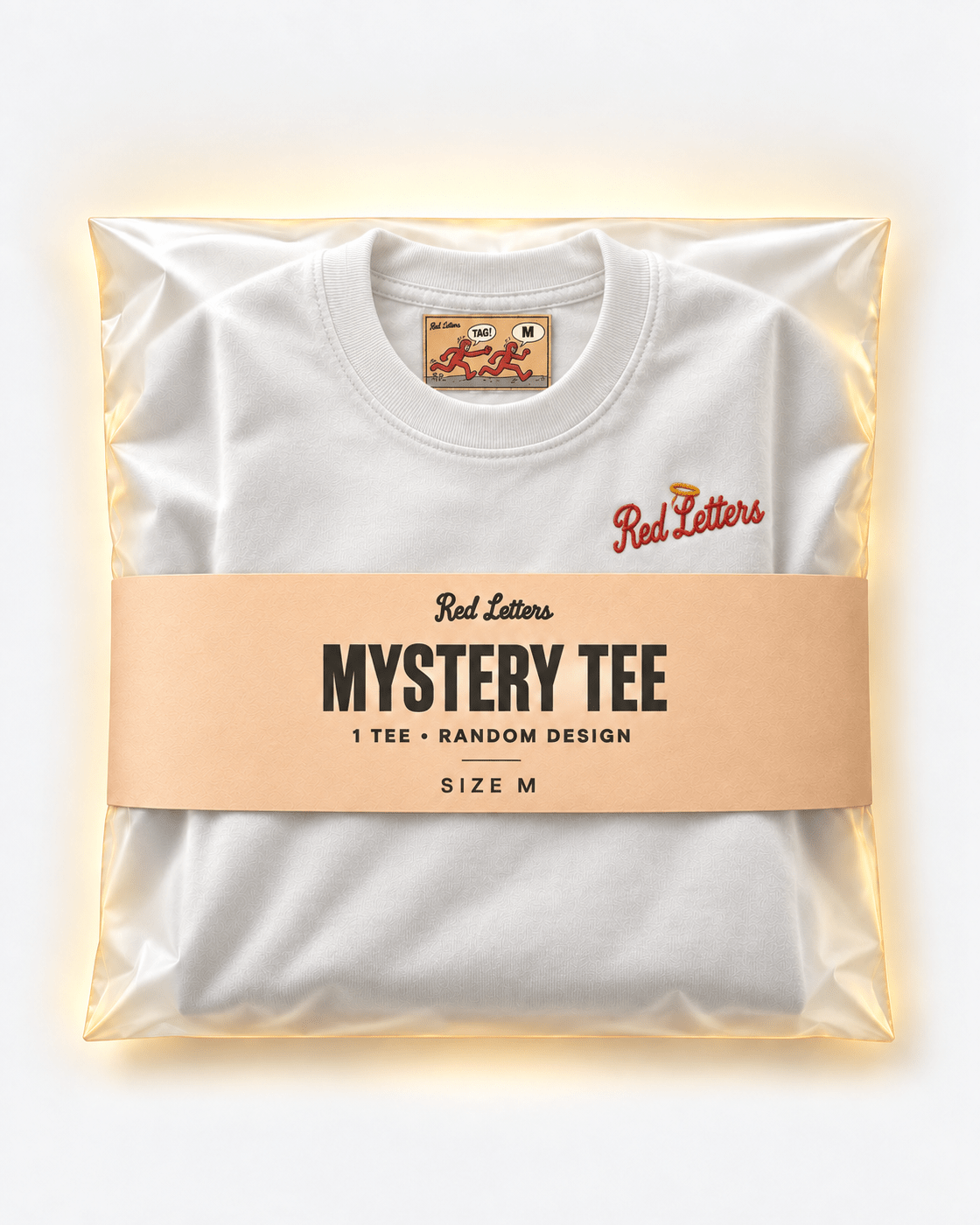 Red Letters Mystery Tee, size M, with a stitched illustrated neck tag, subtle embroidered chest logo and apricot packaging. One tee, random design.